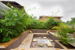 a garden with a patio with benches and plants at SaffronStays Dhyana, Vikramgad in Pālghar