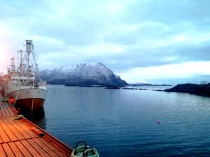 a large boat is docked in a body of water at Kaikanten Rorbuer in Sennesvik +10 photos