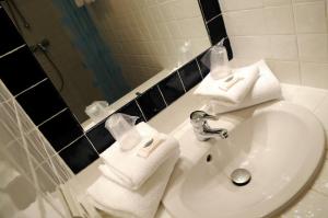 a bathroom with a sink with towels on it at Thalacap Île de Ré - Thalasso & Spa in Ars-en-Ré