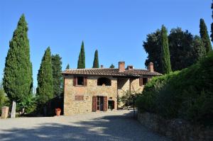 uma grande casa de pedra com árvores e uma entrada em Casa Cesira em Arezzo
