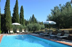 uma piscina com espreguiçadeiras e guarda-sóis em Casa Cesira em Arezzo