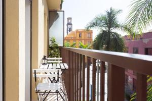 a balcony with a white bench and a palm tree at Monkey house in Santa Cruz de Tenerife