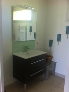een badkamer met een wastafel en een spiegel bij Résidence de Nodeven in Guissény