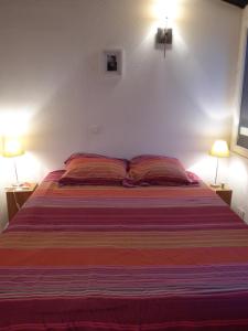 1 dormitorio con 1 cama grande y 2 lámparas en mini-villa, en Grosseto-Prugna