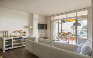 a living room with a white couch and a table at LUXURY GAVA BEACHFRONT APARTMENT BARCELONA in Gavà