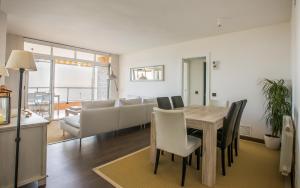 a dining room and living room with a table and chairs at LUXURY GAVA BEACHFRONT APARTMENT BARCELONA in Gavà