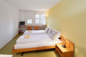 una piccola camera con due letti e una finestra di Seminarhotel Romerohaus a Lucerna