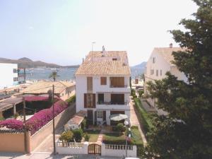 a white house with a tile roof and the ocean at Gola Estada 1A in Port de Pollensa