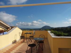 a patio with chairs and tables on a balcony at Le Roverelle in Ilbono