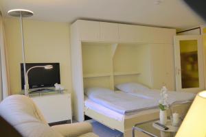 ein kleines Schlafzimmer mit einem Bett und einem TV in der Unterkunft Dirlak in Westerland