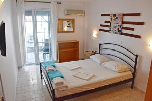 a bedroom with a bed with towels on it at Vicky Studios in Myrina