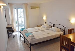 a bedroom with a bed and a table and a window at Vicky Studios in Myrina +12 photos