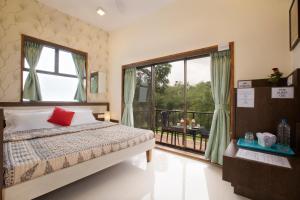 a bedroom with a bed and a balcony at SaffronStays Nithyam - 2BR budget pool villa in Wada, gated community, Wi-Fi, river walk, near Mumbai via NH48 in Pālghar