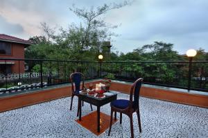 a patio with a table and chairs on a balcony at SaffronStays Nithyam - 2BR budget pool villa in Wada, gated community, Wi-Fi, river walk, near Mumbai via NH48 in Pālghar
