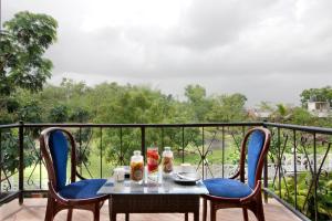 a table and two chairs on a balcony with a view at SaffronStays Nithyam - 2BR budget pool villa in Wada, gated community, Wi-Fi, river walk, near Mumbai via NH48 in Pālghar