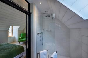 a attic bathroom with a shower and a bed at Les Galets Blancs in Le Conquet