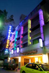 a building with neon signs on the side of it at Taipei Lotty Hotel in Taipei