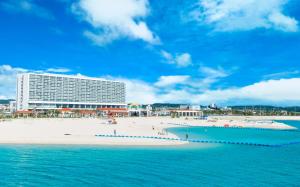 vistas a la playa y a un gran edificio en Southern Beach Hotel & Resort, en Itoman