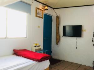 a room with a bed and a flat screen tv at Da Nan Ao Homestay in Ch'ieh-tung
