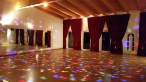 an empty dance floor with red curtains and lights at Landhotel kreien in Kreien