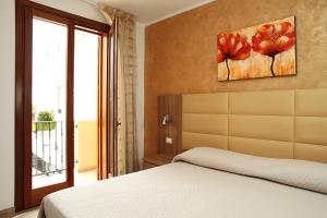 - une chambre avec un lit et une peinture murale dans l'établissement Coralia Bed & Breakfast, à San Vito Lo Capo