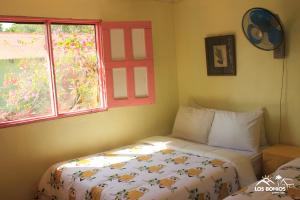 a small bedroom with a bed and a window at Los Bohios Campo Añil in Jarabacoa