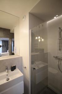 クラクフにあるVIVA Apartamentyのバスルーム(シャワー、シンク、鏡付)