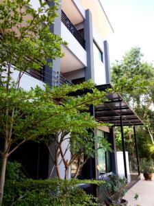 ein Gebäude mit Markise und Bäumen davor in der Unterkunft House 945 in Khon Kaen
