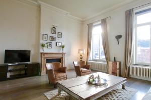 sala de estar con mesa, sillas y TV en Cap's House en Ghent