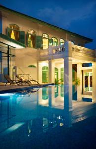 a villa with a swimming pool at night at The Majestic Malacca Hotel - Small Luxury Hotels of the World in Melaka