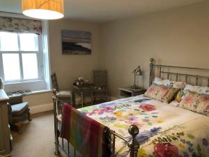a bedroom with a bed with a floral comforter at Dale house barn and B&B in Slaidburn