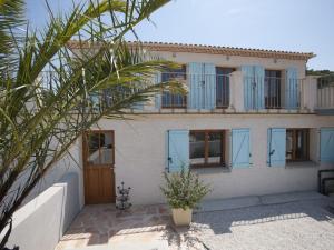 dom z niebieskimi oknami i balkonem w obiekcie Modern villa with private pool in Roquebrun w mieście Roquebrun