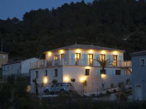 Biały dom z samochodem zaparkowanym przed nim w obiekcie Modern villa with private pool in Roquebrun w mieście Roquebrun