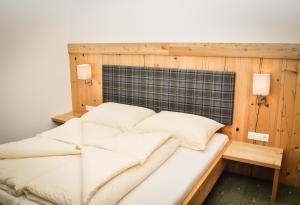 a bed in a room with a wooden wall at Bergruh Steeg in Steeg