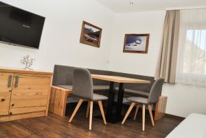 a room with a table and two chairs and a television at Bergruh Steeg in Steeg