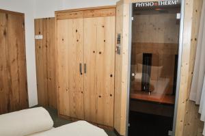 a room with a wooden cabinet and a bed at Bergruh Steeg in Steeg