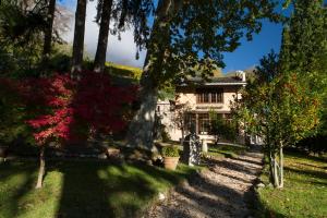 een huis in het midden van een tuin met bomen bij Villa Sizzo Relais B&B in Trento