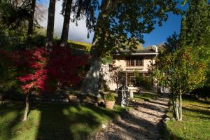 a house in the middle of a yard with trees at Villa Sizzo Relais B&B in Trento