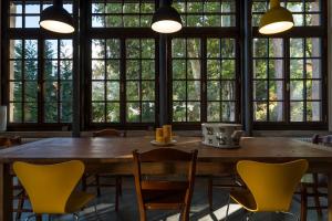 een grote tafel en stoelen in een kamer met ramen bij Villa Sizzo Relais B&B in Trento