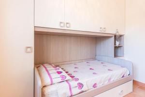 - un petit lit dans un dortoir doté de placards blancs dans l'établissement Villa Safiria, à Carpignano Salentino