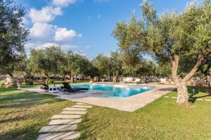 una piscina con 2 sillas y un árbol en Villa Safiria, en Carpignano Salentino