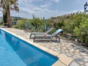 Félines-MinervoisにあるModern villa with private poolのスイミングプールの横に長椅子付きのスイミングプール