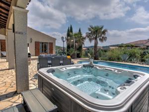 Félines-MinervoisにあるModern villa with private poolのプールの隣の庭にジャグジータブがあります。