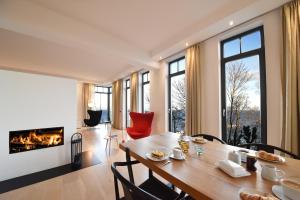 een eetkamer met een tafel en een open haard bij Luxus Apartment Küstenblick in Ostseebad Sellin