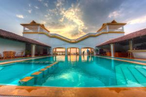 una piscina en un complejo con gente alrededor en Beach Street Eco Resort & Spa, en Mandrem