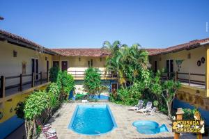 a courtyard with a swimming pool and a house at Pousada Dos Girassois Prado in Prado