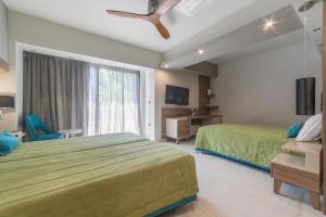 a bedroom with a green bed and a window at Atrion Resort Hotel in Agia Marina Nea Kydonias