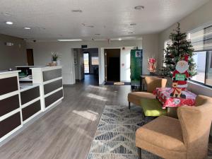 a living room with a christmas tree in the middle at Super 8 by Wyndham Waxahachie TX in Waxahachie