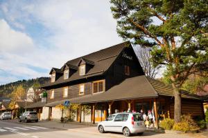 a large building with a car parked in front of it at Pensjonat Maria 2 in Szczyrk