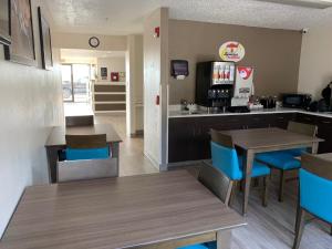 a kitchen with a table and chairs and a refrigerator at Super 8 by Wyndham Waxahachie TX in Waxahachie